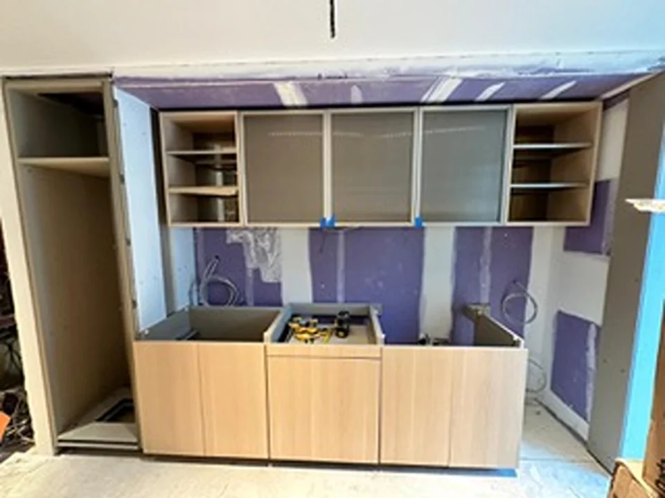 a kitchen under construction with purple walls