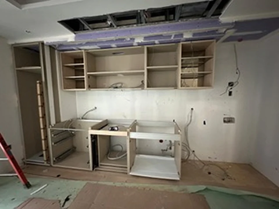 a kitchen under construction with a ceiling and cabinets