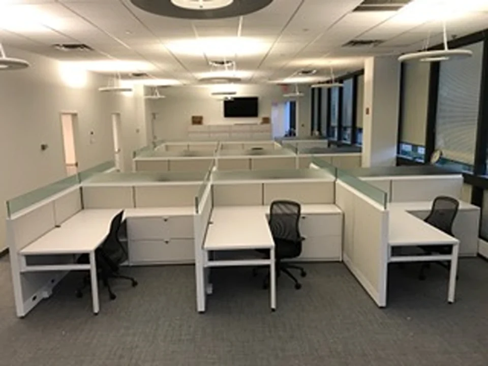 an office cubicles with white desks and chairs