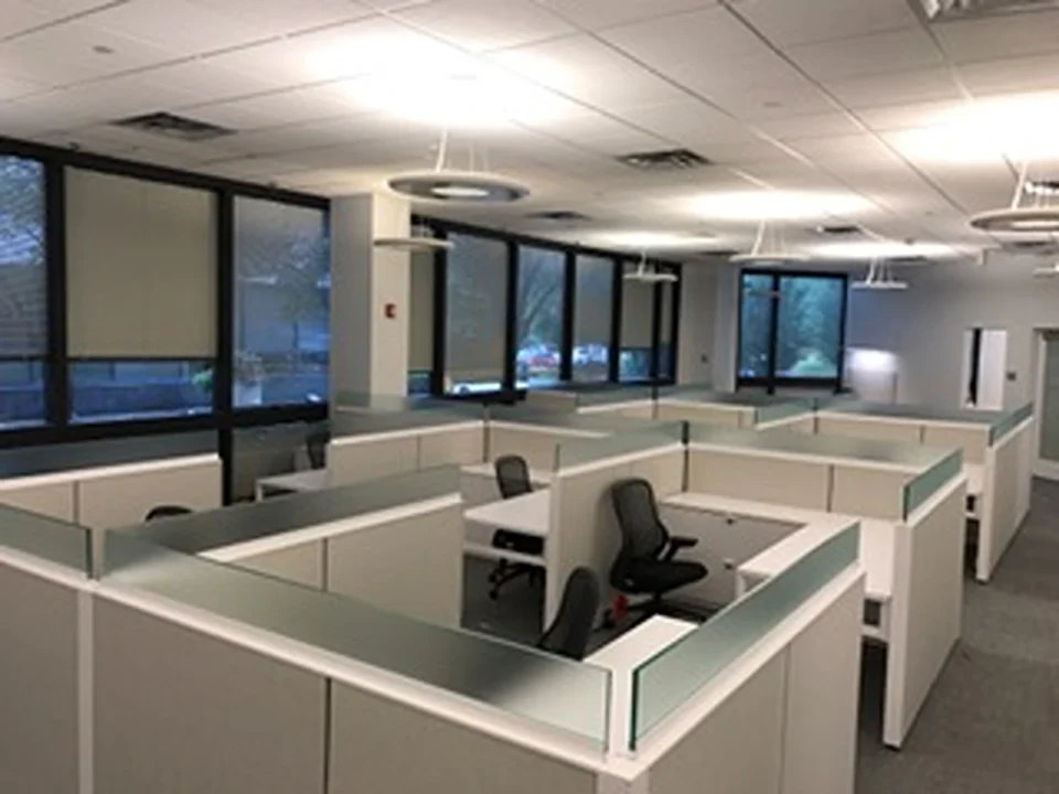 an office cubicles with a desk and chairs