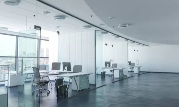 a room with a glass wall and a desk with computers