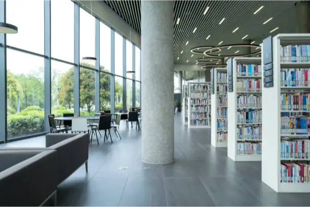 a library with a large column and a large couch